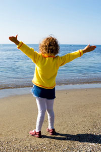 little girl standing by ocean
