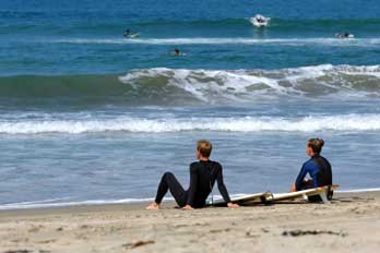 two surfers sitting on the beach, CA