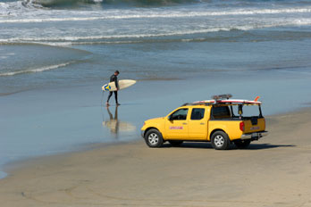 Surfer walking along Huntington Beach, Orange county, CA